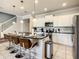 Bright kitchen featuring a spacious island with seating and modern stainless steel appliances at 8911 Geneve Ct, Kissimmee, FL 34747
