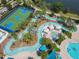 An aerial view of a winding lazy river, with palm trees, seating, and a basketball court nearby at 8911 Geneve Ct, Kissimmee, FL 34747