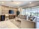 Living area features a decorative wood panel wall, plush seating, and sliding glass doors to an enclosed pool at 8911 Geneve Ct, Kissimmee, FL 34747