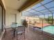 The screened patio with outdoor dining and lounge area overlooks a private pool and landscaped surroundings at 8911 Geneve Ct, Kissimmee, FL 34747