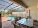 Covered patio featuring outdoor dining area with view of private pool and surrounding greenery at 8911 Geneve Ct, Kissimmee, FL 34747