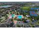 Wide aerial view of a neighborhood featuring pools, tennis courts, parks, and lakes at 9979 Winnington St, Orlando, FL 32832