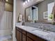 Bathroom showcasing dual sinks with granite countertops and dark wood cabinets at 9979 Winnington St, Orlando, FL 32832