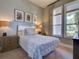 Well-lit bedroom featuring neutral walls, white-trimmed windows, and decorative wall art at 9979 Winnington St, Orlando, FL 32832