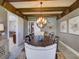 Dining area with exposed beam ceilings, seating for eight, and sliding barn door at 9979 Winnington St, Orlando, FL 32832