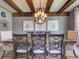 Dining room showing exposed beam ceilings, a wooden table, and decorative wall art at 9979 Winnington St, Orlando, FL 32832