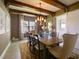 Elegant dining room featuring wood beam ceilings, stylish chandelier, and large window for natural light at 9979 Winnington St, Orlando, FL 32832