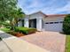 Charming single-story home with a brick paver driveway, lush landscaping, and attached garage at 9979 Winnington St, Orlando, FL 32832