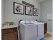 The laundry room has modern appliances, storage cabinets, and a folding table for convenience at 9979 Winnington St, Orlando, FL 32832