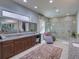 The spacious main bathroom has granite counters, dual vanities, a chaise lounge, and a tiled shower at 9979 Winnington St, Orlando, FL 32832