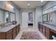 This bathroom boasts double vanities and is accented with a patterned rug at 9979 Winnington St, Orlando, FL 32832