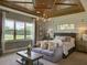 Serene bedroom showcasing decorative ceiling, large windows with beautiful backyard views, and cozy seating at 9979 Winnington St, Orlando, FL 32832