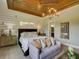 This bedroom has a tray ceiling, a chandelier, and plenty of space for relaxing and sleeping at 9979 Winnington St, Orlando, FL 32832