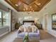 A serene main bedroom boasts a tray ceiling, sitting area, and natural light from a large window at 9979 Winnington St, Orlando, FL 32832