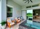 Patio area with orange cushioned seating and a view of a swimming pool at 9979 Winnington St, Orlando, FL 32832