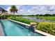 Stunning pool with a water feature overlooking a pond and lush green landscape at 9979 Winnington St, Orlando, FL 32832