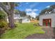 View of the spacious backyard with a shed, grassy area, and mature trees at 1021 S Elm Ave, Sanford, FL 32771