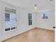 Light-filled bedroom with hardwood floors and three windows showing views of the exterior at 1021 S Elm Ave, Sanford, FL 32771