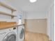 Well-lit laundry room equipped with a washer, dryer, storage shelves, and neutral toned walls at 1021 S Elm Ave, Sanford, FL 32771