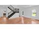 Light-filled living room boasts hardwood floors, a staircase, and access to the front and rear of the home at 1021 S Elm Ave, Sanford, FL 32771