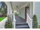 Spacious front porch with white railings, a red entry door, and a stylish address number at 1021 S Elm Ave, Sanford, FL 32771