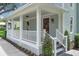 Close-up of a charming front porch with white columns, a red door, and address number 1021 at 1021 S Elm Ave, Sanford, FL 32771