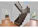 Bright entryway showcases hardwood floors, staircase with dark wood banister, and white walls at 1021 S Elm Ave, Sanford, FL 32771