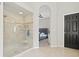 Tiled shower and archway to a bedroom create an open and airy feel in this bright bathroom at 1103 Lake Legro Ct, Orlando, FL 32835