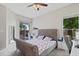 Cozy primary bedroom boasts a tufted headboard, a ceiling fan, and sliding door access to the outdoors at 1103 Lake Legro Ct, Orlando, FL 32835