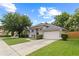A well-maintained single-story home with a neatly landscaped lawn and a spacious two-car garage at 1103 Lake Legro Ct, Orlando, FL 32835