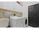 Functional laundry room includes storage cabinets, modern appliances, and a utility sink at 1103 Lake Legro Ct, Orlando, FL 32835
