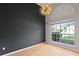 A room featuring dark accent wall, modern chandelier, large window, and hardwood floors at 1103 Lake Legro Ct, Orlando, FL 32835