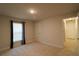 Bright bedroom featuring neutral carpet, a window with curtains, and an entry door at 1105 Citrus Landings Blvd, Davenport, FL 33837