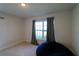 Cozy bedroom with neutral carpet, a window providing natural light, and a comfortable beanbag chair at 1105 Citrus Landings Blvd, Davenport, FL 33837