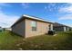 A low angle view of the rear exterior of a home with simple architectural details and an air conditioning unit at 1105 Citrus Landings Blvd, Davenport, FL 33837