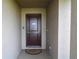 Close-up of a brown front door with a 'No Soliciting' sign and welcome mat at 1105 Citrus Landings Blvd, Davenport, FL 33837