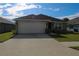 Charming single-story home featuring a well-maintained lawn and attached two-car garage at 1105 Citrus Landings Blvd, Davenport, FL 33837