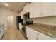 Contemporary kitchen with stainless steel appliances, granite countertops, and white cabinets at 1105 Citrus Landings Blvd, Davenport, FL 33837