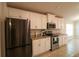 The kitchen is equipped with stainless steel appliances and sleek white cabinetry at 1105 Citrus Landings Blvd, Davenport, FL 33837