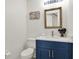 Stylish powder room features blue vanity, modern fixtures, and attractive seashell wall decor at 12347 Ne 52Nd Loop, Oxford, FL 34484