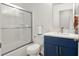 A modern bathroom featuring stylish, blue vanity, quartz countertops, and sliding shower doors at 12347 Ne 52Nd Loop, Oxford, FL 34484