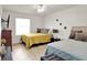 A modern bedroom featuring two beds, neutral tones, wood flooring, and ample natural light at 12347 Ne 52Nd Loop, Oxford, FL 34484