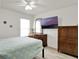 A well-lit bedroom with a ceiling fan, a large window, and natural wood furniture accents at 12347 Ne 52Nd Loop, Oxford, FL 34484