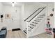 A clean entryway with white walls and contrasting black and white stairs with natural light at 12347 Ne 52Nd Loop, Oxford, FL 34484