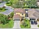 Two-story home with a two-car garage, a well-manicured lawn, and lush landscaping at 12347 Ne 52Nd Loop, Oxford, FL 34484