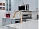 A kitchen featuring quartz countertops, stainless steel appliances, blue cabinets, and modern gold fixtures at 12347 Ne 52Nd Loop, Oxford, FL 34484