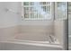 Bright bathroom with jetted tub, tile surround and window at 1457 Teal Dr, Kissimmee, FL 34759