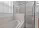 Bright bathroom features a tub, tile surround, and a glass shower door at 1457 Teal Dr, Kissimmee, FL 34759