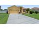 View of the home with long driveway, two-car garage, and manicured lawn at 1457 Teal Dr, Kissimmee, FL 34759