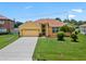 Charming yellow single-story home with well-manicured lawn and attached two-car garage at 1457 Teal Dr, Kissimmee, FL 34759